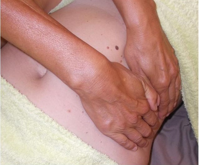 photo de mains qui massent un ventre.